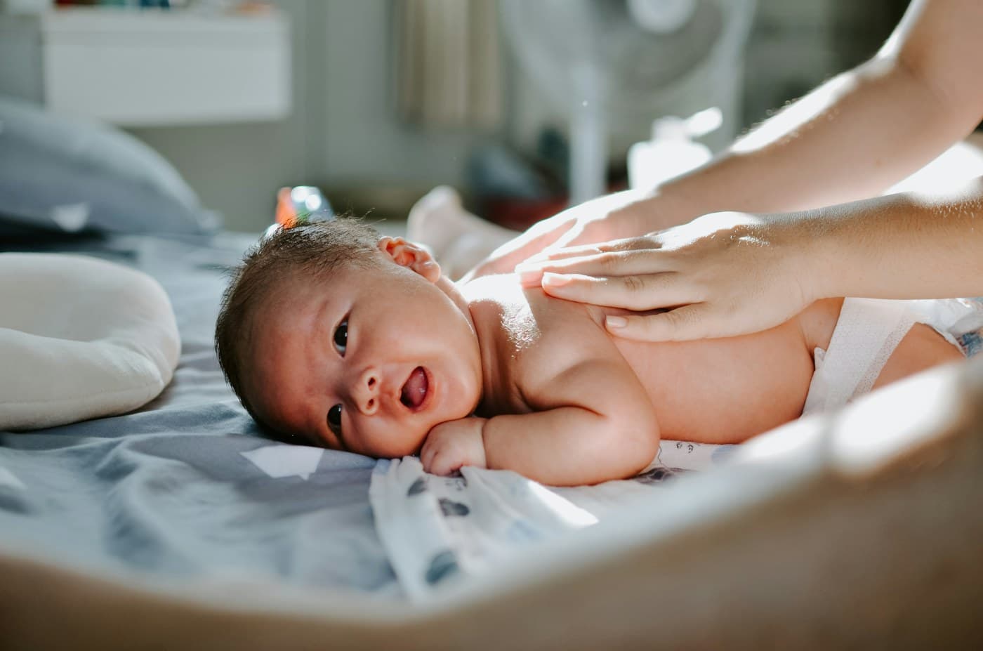 Bayi tersenyum saat dipijat dengan lembut