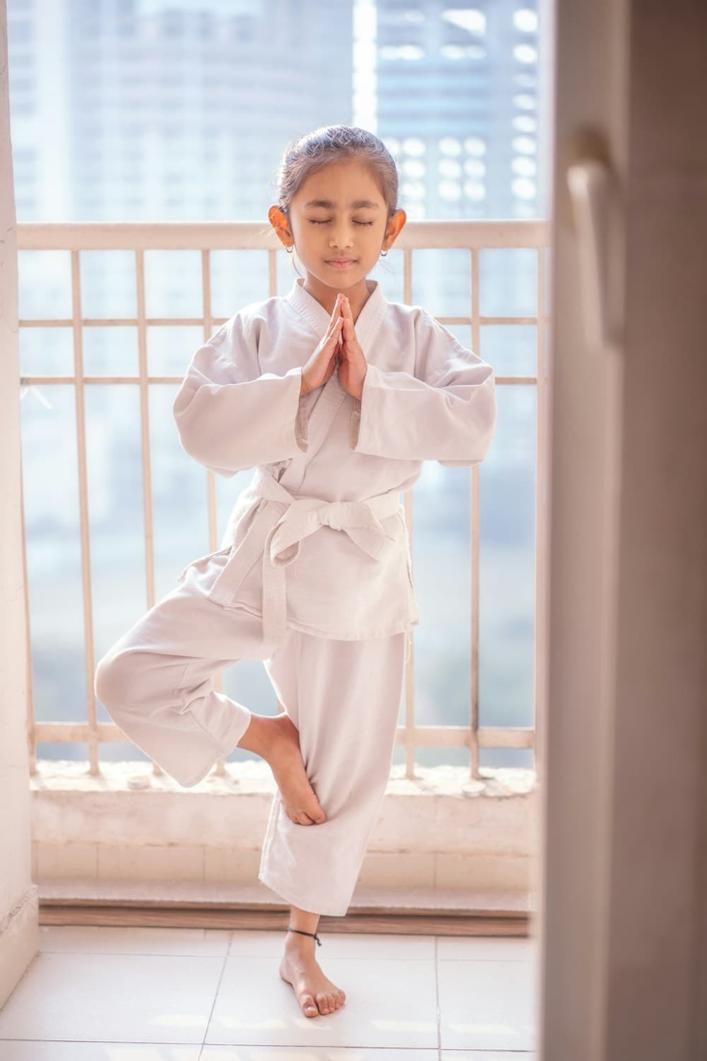 Anak perempuan berlatih pose yoga pohon